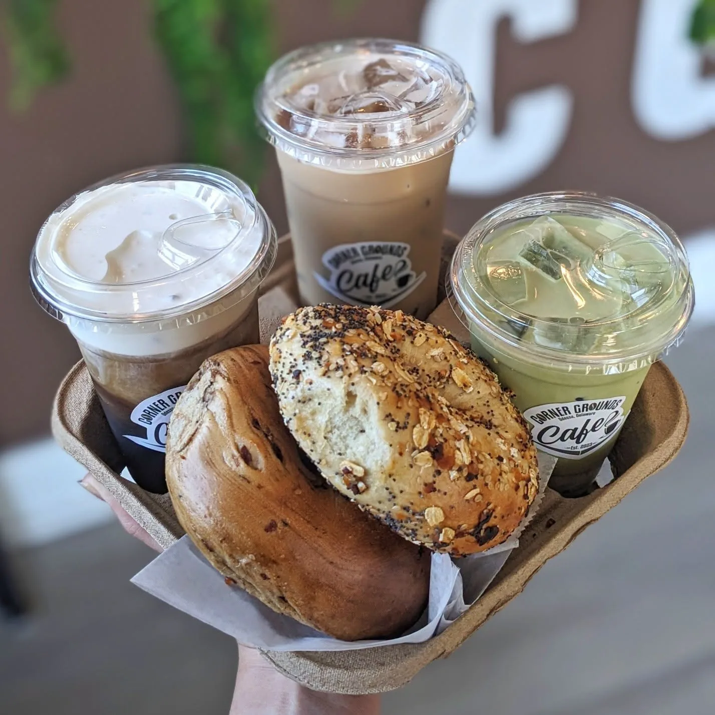 A carry tray with iced coffee, iced matcha and fresh bagels from Corner Grounds Café