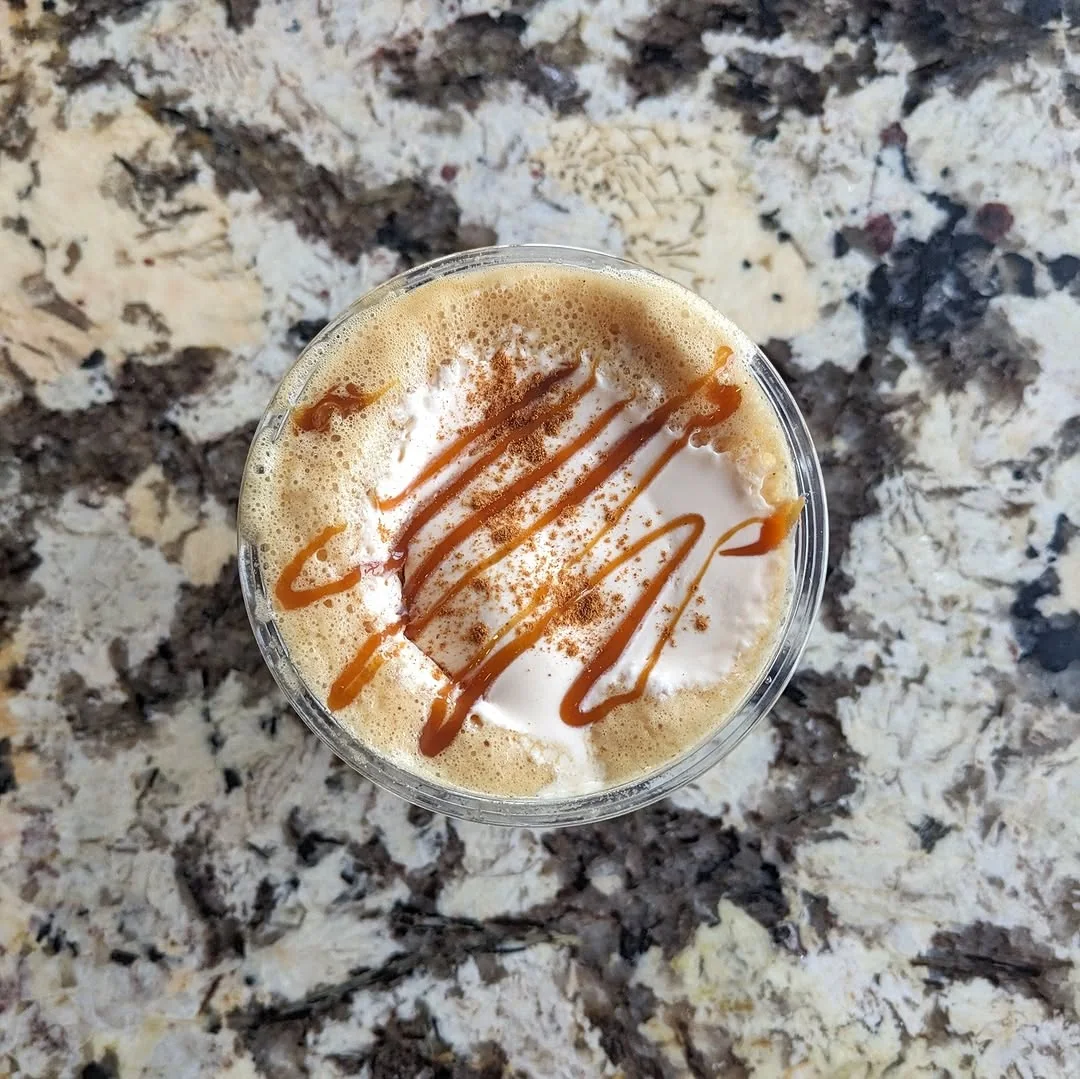 Overhead view of cinnamon and caramel-topped coffee